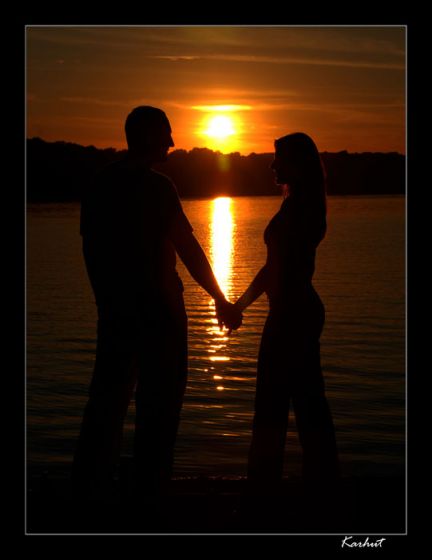Фото Девушка с парнем держась за руки стоят в воде