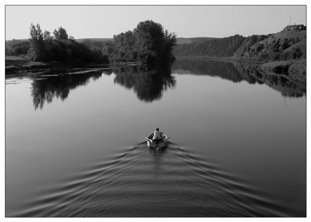 Фото Мужчина плывёт в лодке по реке