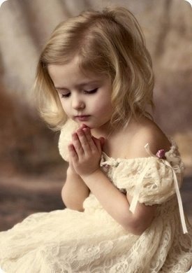 Маленькая девочка молится или мечтает в парке под открытым небом.