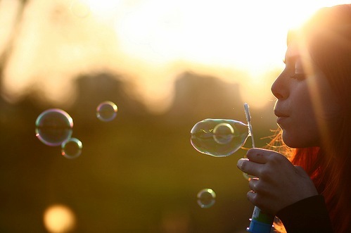 Фото Девушка выдувает мыльные пузыри