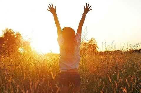 Фото Девушка бежит подняв руки в поле на встречу закату