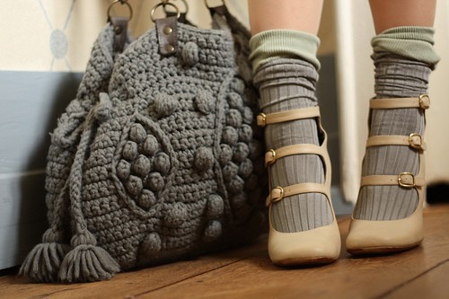 Фото Серая вязанная сумка и ножки девушки в гольфах и туфельках