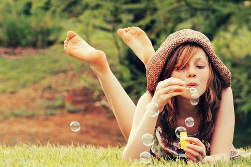 Фото Девушка в шляпке выдувает мыльные пузыри