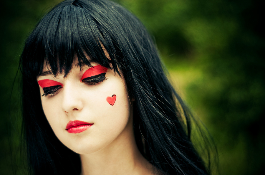 Фото Девушка с черными волосами,красным макияжем век и губ и сердечком на щеке