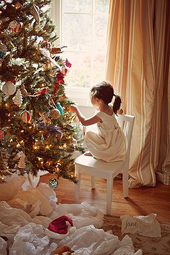 Фото Маленькая девочка украшает ёлку