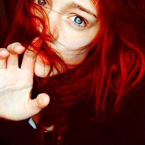Фото Девушка с красными волосами приложила указательный палец к губам