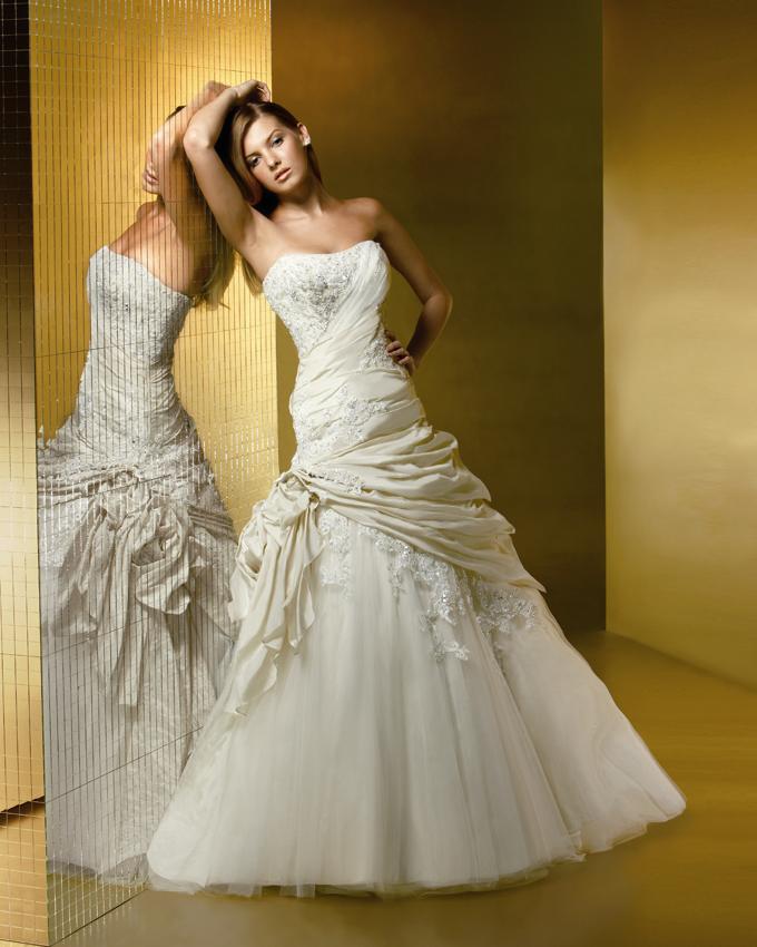 Фото Девушка стоит возле зеркала в белом платье