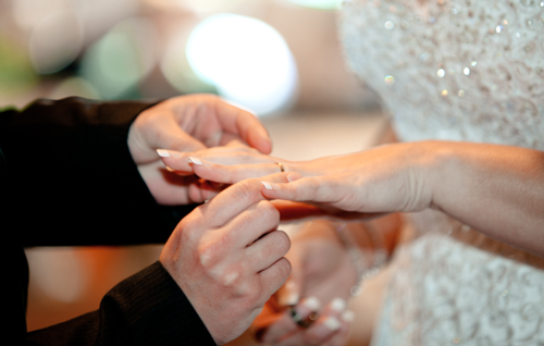 Фото Жених одевает кольцо на палец невесте