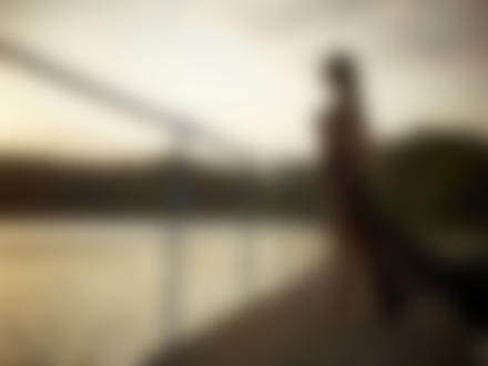Фото Обнажённая девушка в длинной накидке стоит на причале