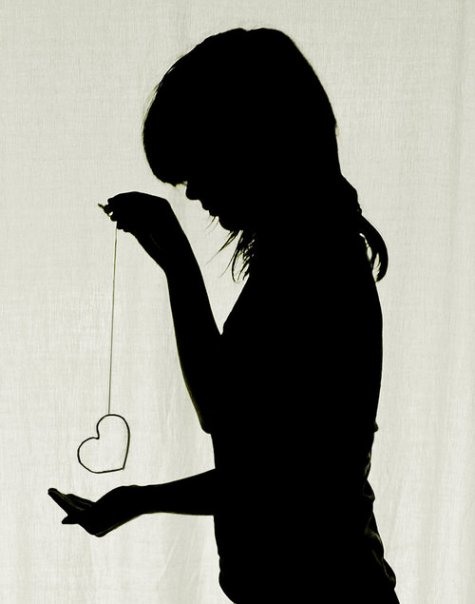 Фото Силует девушки, которая держит сердце на нитке