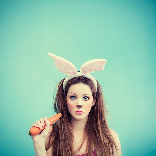 Фото Девушка с ушками кролика с морковкой в руке