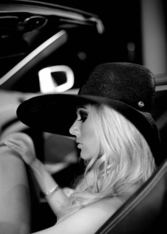 Фото Девушка-блондинка в шляпе сидит в автомобиле