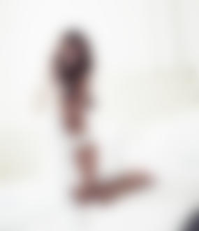 Фото Милая улыбающаяся девушка в белой комнате прикрыла обнаженное тело одеялом, студийные гламурные работы фотографа Simon Emmet