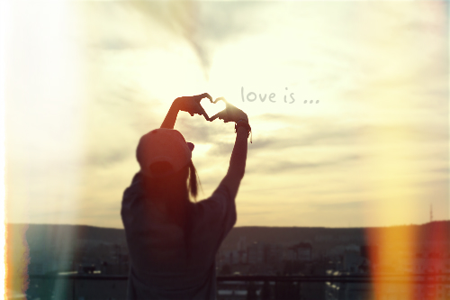 Фото Девушка на крыше сделала сердечко из рук 'love is' / 'любовь это'