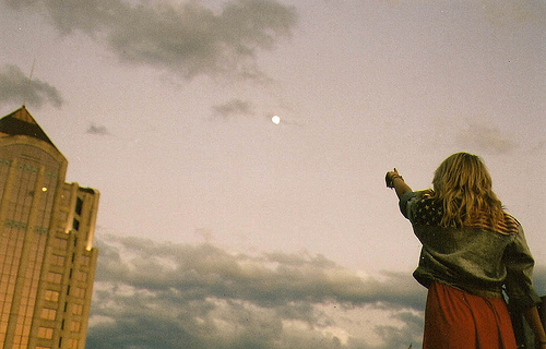 Фото Девушка показывает на небо, где находится полная луна