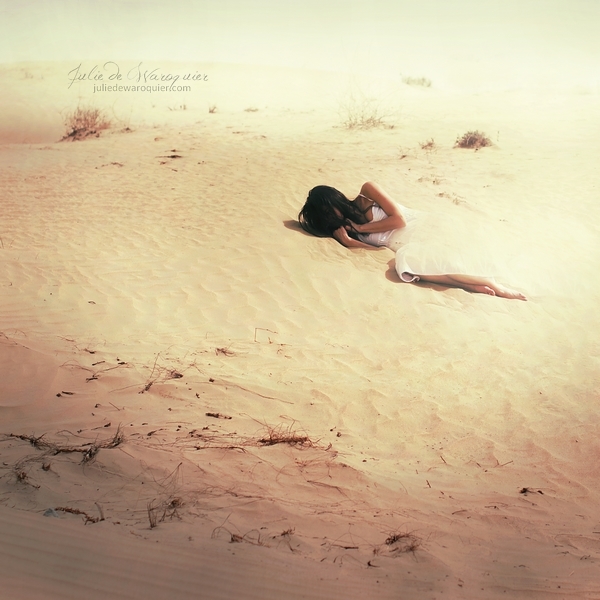 Фото Печальная девушка в белом платье лежит на песке в пустыне, фотограф Julie de Waroquier / Джули Де Варокьер