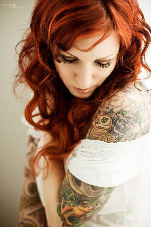 Фото Красивая рыжеволосая девушка с татуированным предплечьем
