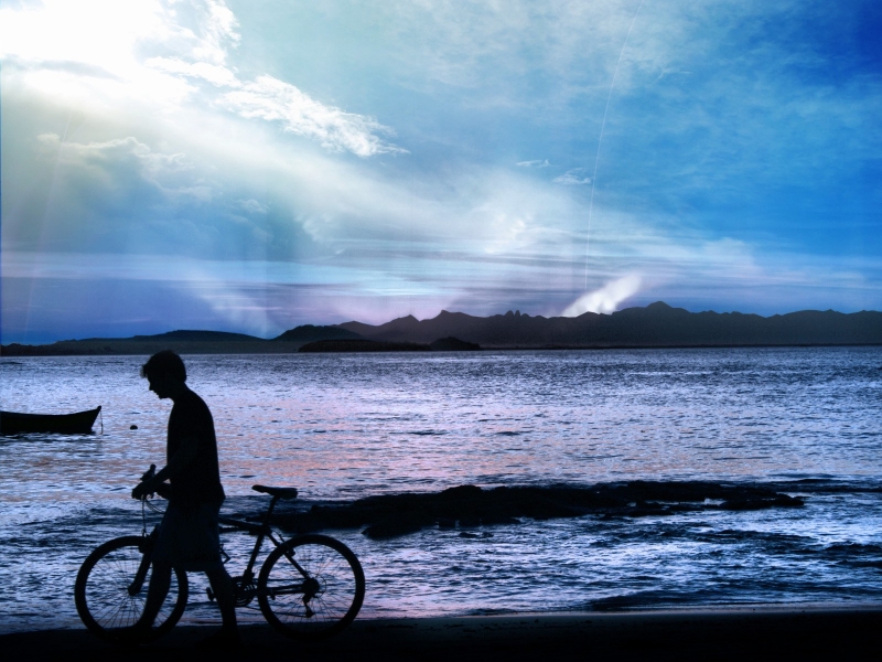 Фото Мальчик, идущий с велосипедом по берегу озера