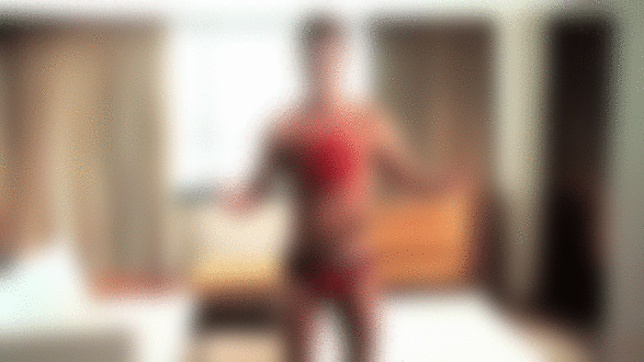 Фото Мужчина в красном нижнем белье и с бантом на груди улыбается разводя руки