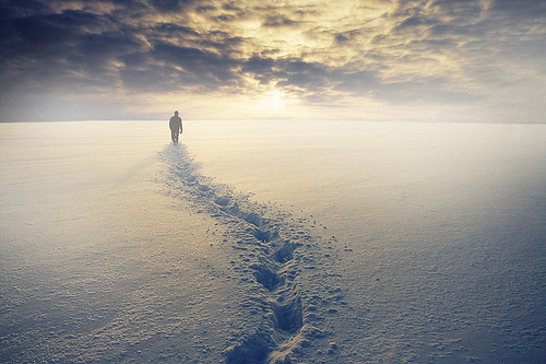 Фото Мужчина, уходящий вдаль, и его следы на снегу