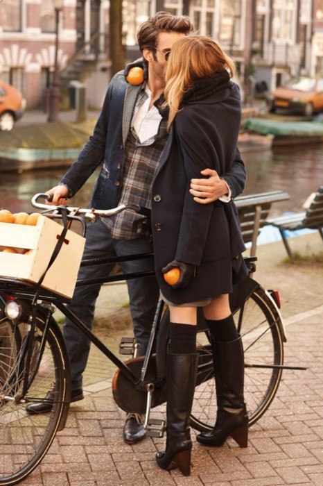Фото Мужчина целует девушку, сидя на велосипеде