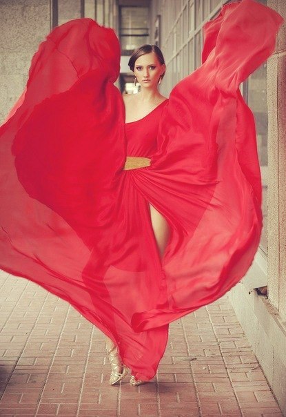 Фото Девушка в красном платье которое развивает ветер