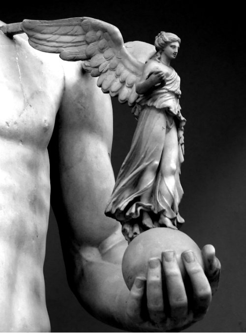 Фото Элемент скульптуры- мужская рука держит шар, на котором стоит девушка-ангел
