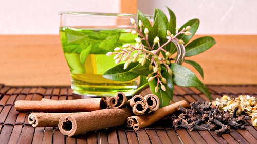 Фото Зеленый чай рядом с лежащей корицей