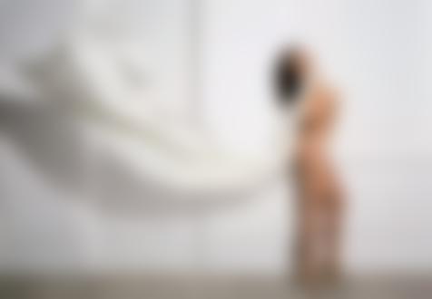 Фото Надя Ручка / Nadia Ruchka стоит обнажённая у стены, придерживая развивающуюся на ветру белую ткань
