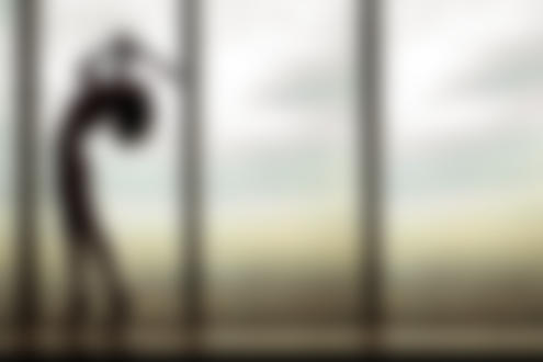 Фото Обнаженная девушка стоит на подоконнике окна на фоне города и неба