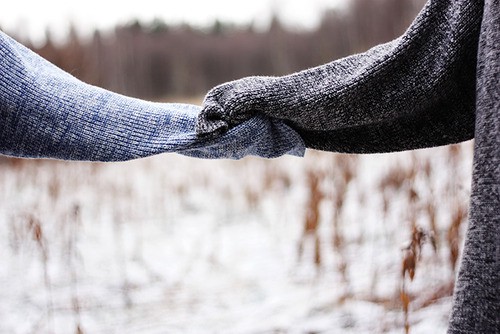 Фото Две руки, укутанные в свитер, держатся друг за друга