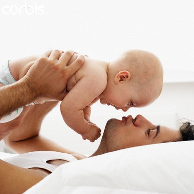 Фото Мужчина хочет поцеловать малыша держа его в руках