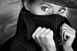 Фото Девушка в темной шляпе в одежде с высоким воротником прикрыла лицо черным шарфом