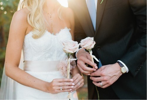 Фото Жених и невеста держат в руках по розе