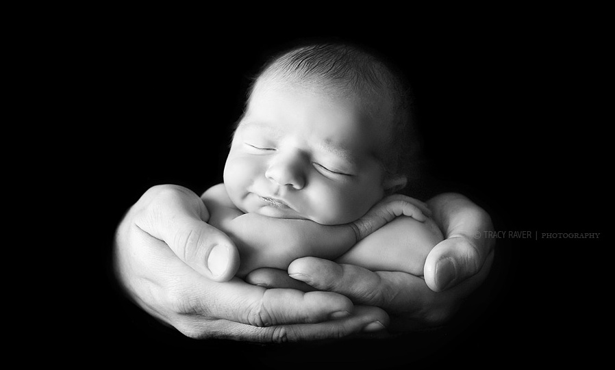 Фото Новорождённый малыш спит в ладошках отца, фотограф Трейси Рейвер / Tracy Raver