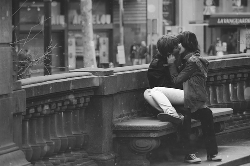 Фото Девушка сидит на руках у мужчины, целуясь с ним