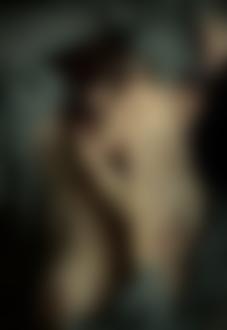 Фото Девушка с обнаженной грудью держит одну руку у подбородка, другую поверх головы