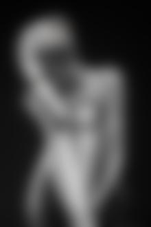 Фото Обнаженная серебристая девушка с браслетами на руке и колене на черном фоне