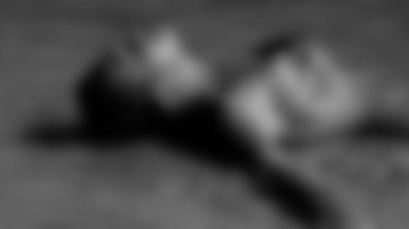 Фото Девушка с каплями на теле лежит на берегу моря, прикрывая грудь рукой