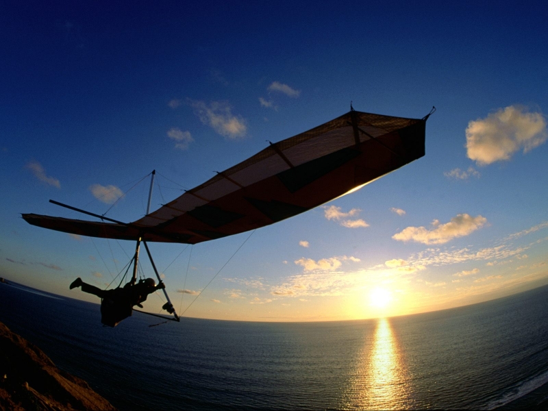 Фото Дельтапланерист над морем и солнцем