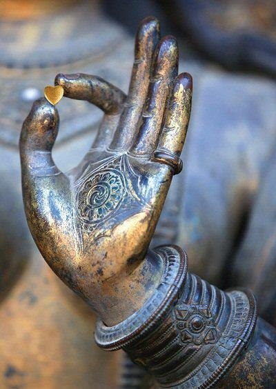 Фото Железная рука Будды держит маленькое сердце