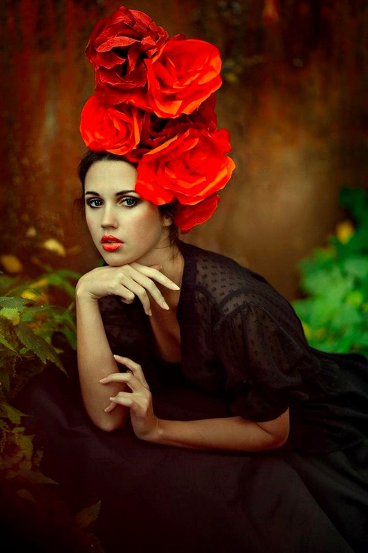Фото Девушка в черном платье и с огромными красными розами на голове