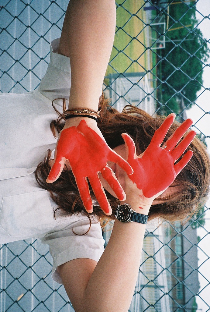 Фото Девушка закрыла лицо перемазанными в красной краске руками