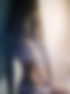 Фото Девушка с обнаженной грудью в белой юбке сидит у стены, вокруг нее дым
