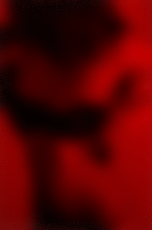 Фото Девушка при красном освещении одевает черный лифчик