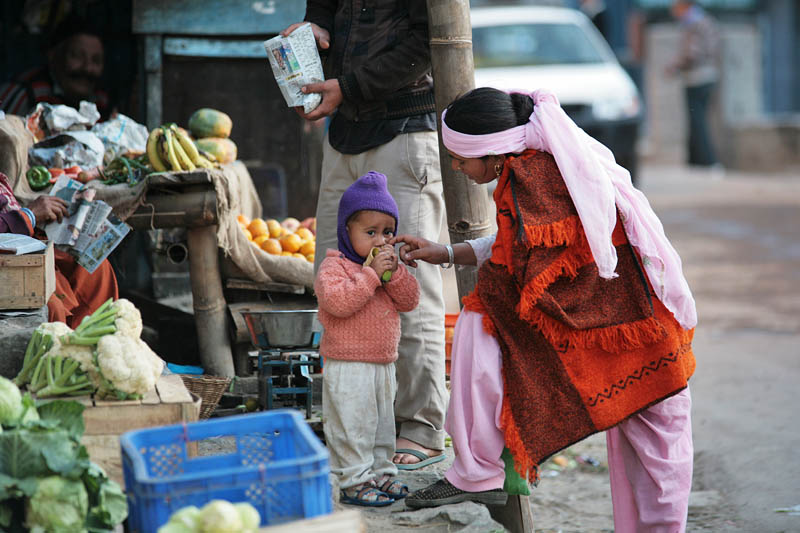 Фото Женщина кормит ребенка, рядом стоят торговцы