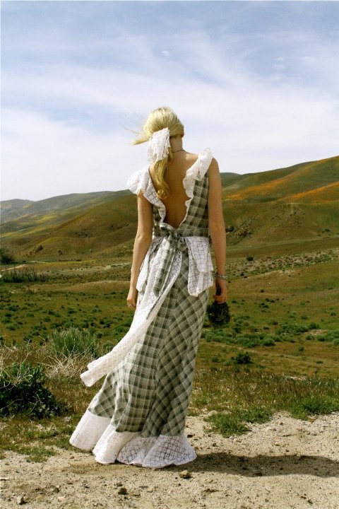 Фото Девушка в длинном клетчатом платье любуется горами