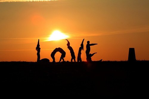 Фото Эмблема 'Love' из фигур людей на фоне заходящего солнца