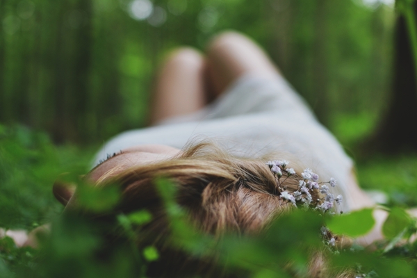 Фото Девушка в белом платье лежит на траве
