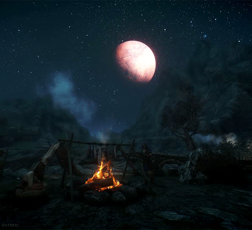 Фото Горящий костер в ночи  под луной и звездами расстилается дым от него